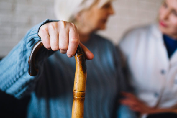 Older woman with walking sticks talking to support worker