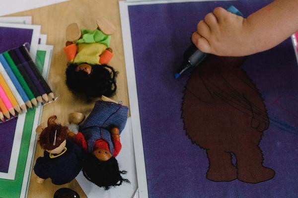 Woman and child's hands on table drawing