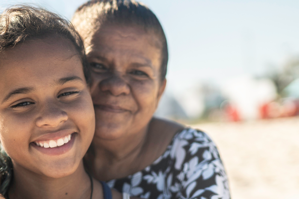 Woman hugging adolescent grand daughter smiling