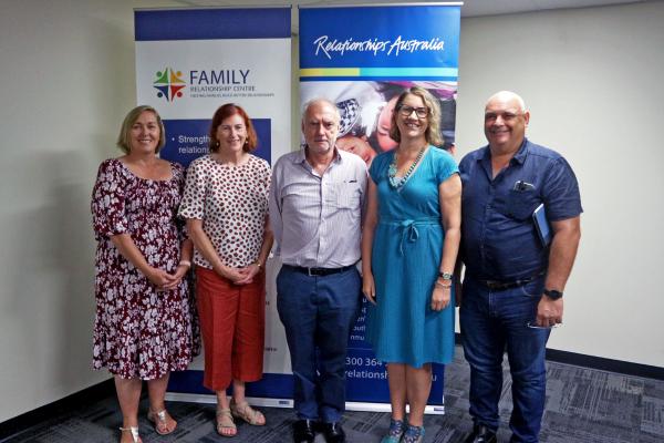 Group of people standing in front of banner smiling